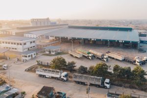 An aerial shot of factory trucks parked near the warehouse at daytime